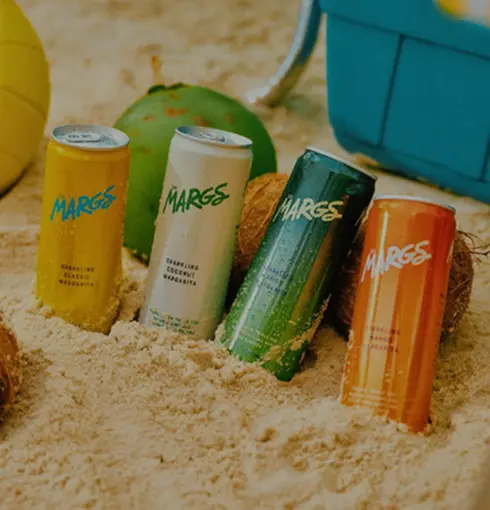 colorful-beverage-cans-beach-sand-tropical-drinks